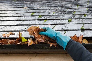 hand cleaning dirty gutter
